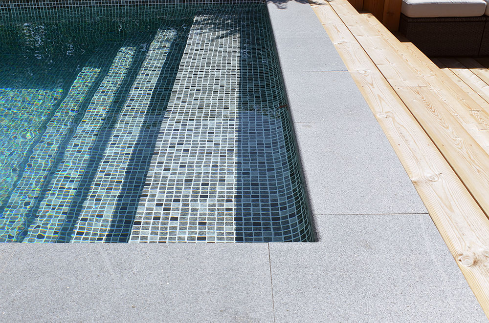 Gaveltrappan på poolen ger skön sittyta och med mosaikliner blir det snygg Pool inspiration