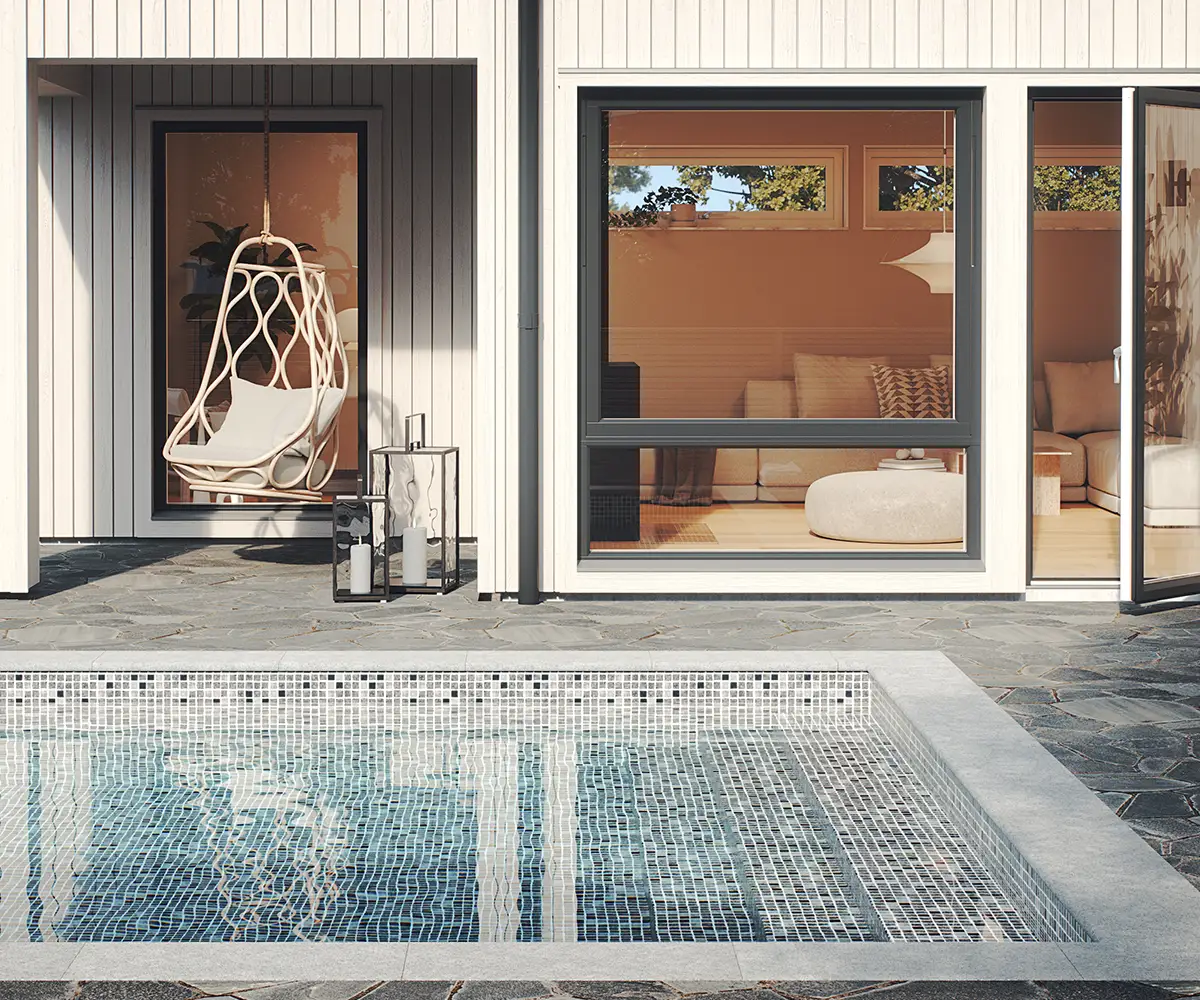 En härlig sittplats med utsikt över en pool med grå mosaikliner