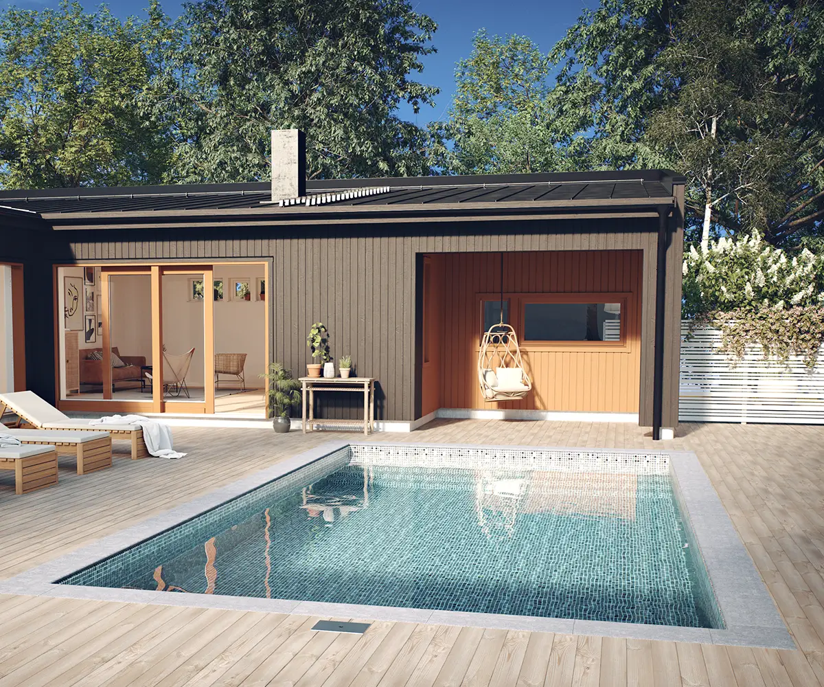 En vackert nedsänkt pool i en altan omgiven av kantsten och ett poolhus